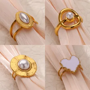 Macro detail of French vintage style gold rings with pearls and heart enamel