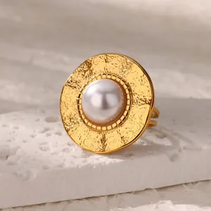 Detail of vintage gold heart ring featuring hammered metal texture and large faux pearl