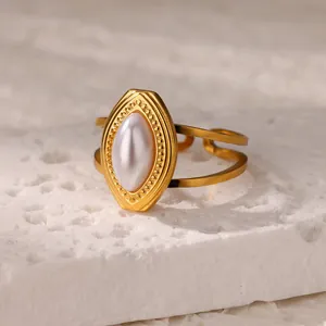 Close-up of vintage gold stainless steel ring with elegant faux pearl inlay detail