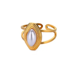 Macro detail of vintage gold heart ring featuring marquise faux pearl and beaded texture