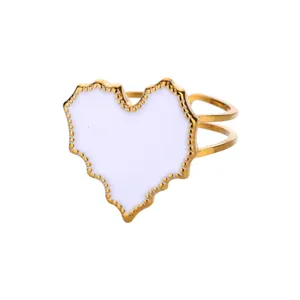 Detailed close-up of heart-shaped white enamel ring with golden scalloped edges and dual-band