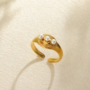 Detail of gold-plated ring with three pearls and radiant textured oval design