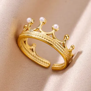 Macro shot of crown shaped gold ring with white pearls on elegant champagne satin