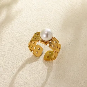 Macro shot of gold hollow geometric woven ring featuring a large white round pearl