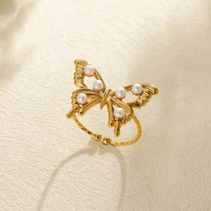 Detail view of golden butterfly ring with six white pearls and twisted rope band