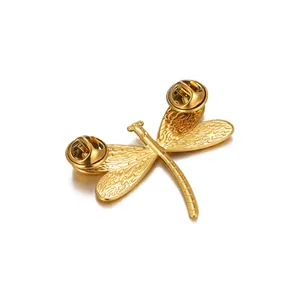 Detail view of a vintage dragonfly brooch with carved wing textures and double metal pins
