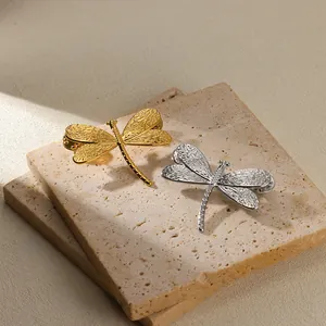 Detail of vintage dragonfly brooch with intricate embossed patterns on metal wings
