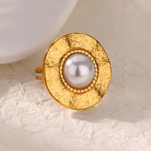 Detailed macro view of the vintage gold-plated ring with a central pearl and hammered metal finish