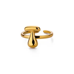 Detail van 18K vergulde ring met bubble letter T en een waterdruppel vormig design