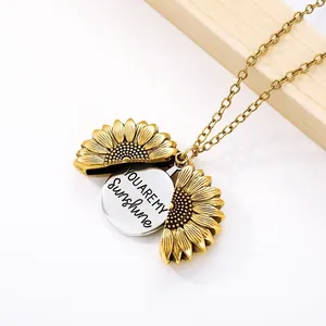 Macro detail of openable sunflower necklace with 'YOU ARE MY Sunshine' engraved inside