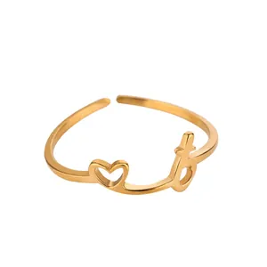 Détail de bague dorée avec motif cœur et lettre 't' dans un style minimaliste élégant