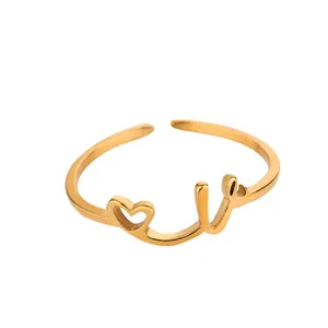 Détail d'une bague dorée ajustable avec cœur évidé et lettrage Love manuscrit