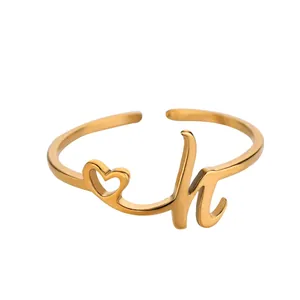 Détail de la bague coeur dorée avec lettre H et anneau ouvert ajustable élégant
