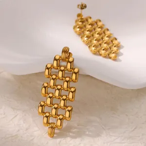 Close-up of elegant gold plated U-shaped linked earrings with a polished geometric texture