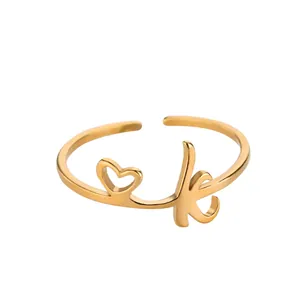 Détail d'une bague coeur dorée ajustable avec la lettre K gravée en style cursif