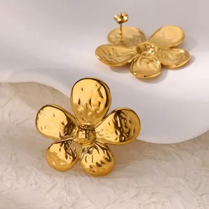 Macro shot of gold-plated camellia stud earrings with unique hammered metal texture