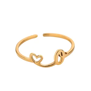 Détail d'une bague en acier doré avec cœur évidé et lettre O personnalisée