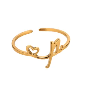Vue détaillée de la bague ajustable dorée avec cœur évidé et lettre M élégante
