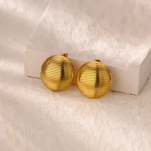 Macro detail of gold-plated camellia flower stud earrings with wavy texture on stone