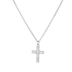 Close-up of silver cross necklace featuring baguette-cut zircon and milgrain details