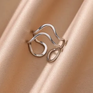 Dettaglio dell'anello aperto a doppia onda argentato su tessuto in seta elegante