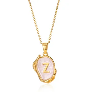 Macro detail of 18K gold plated necklace featuring 3D letter Z on pink enamel pendant