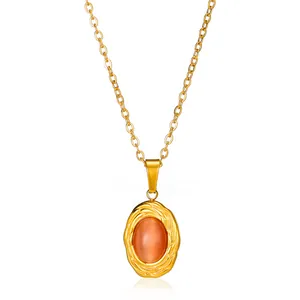 Macro detail of the golden vine texture frame and orange cat eye stone pendant