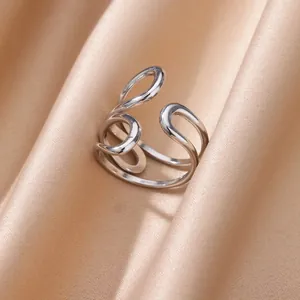 Dettaglio dell'anello d'argento con linee minimaliste su sfondo in seta satinata champagne