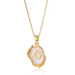 Detail of 18K gold-plated necklace featuring a purple enamel pendant with capital letter Q