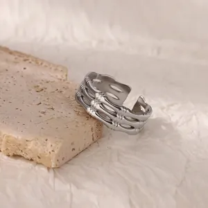 Detailed close-up of a silver-toned bamboo style tiered ring on a textured stone surface