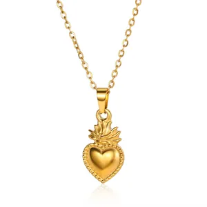 Détail du pendentif cœur sacré doré avec motif de couronne et finition polie brillante
