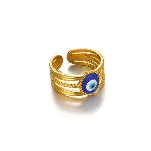 Macro detail of gold-plated evil eye ring featuring a layered rope texture band