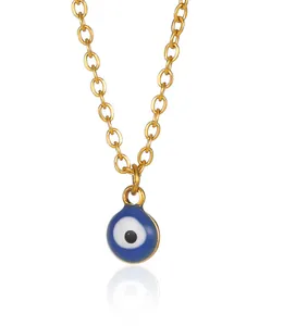 Detail view of gold 18K plated Evil Eye pendant necklace with blue enamel on white background