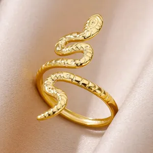 Close-up of gold snake ring with detailed scale textures on elegant silk fabric