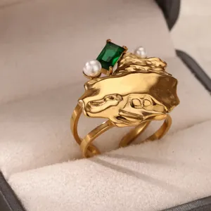 Detail eines 18k Goldrings mit grünem Edelstein und weißen Perlen in der Schmuckschatulle