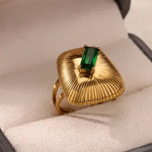 Detail eines Vintage-Goldrings mit grünem Stein und gravierter Sonnenstrahl-Textur