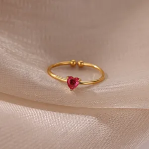 Macro view of adjustable gold-plated ring with a heart-shaped red zircon gemstone
