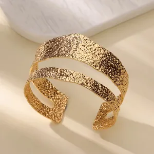 Detail view of the golden double-layered cuff bracelet featuring a unique hammered texture