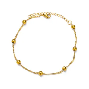 Detail of twisted gold chain anklet with polished beads and lobster clasp adjustment