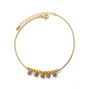 Detailed close-up of 18K gold-plated anklet featuring blue evil eye charms and lobster clasp
