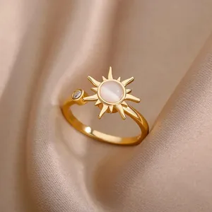 Detalle de anillo de sol dorado con piedra ojo de gato y circón sobre seda suave