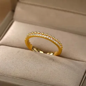 Detalle del anillo eternity dorado con pavé de circonitas y borde de cuentas artesanales