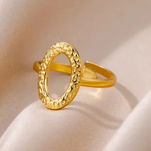 Primer plano de anillo dorado martillado con diseño ovalado y banda abierta ajustable
