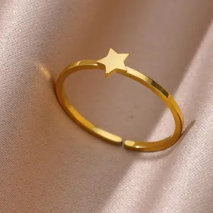 Detailed shot of golden adjustable ring featuring a minimalist star element on silk fabric