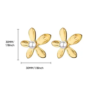 Detalle de los pendientes de flores doradas de 30mm con perla blanca y textura metal