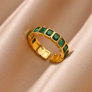 Macro shot of gold-plated ring featuring green rectangular emerald-cut zircon stones