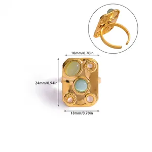 Detailed view of rectangular vintage gold ring with green zircon and weave texture