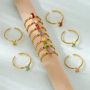 Close-up of golden adjustable rings with colorful rectangular zircon stones on display