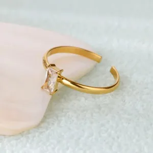 Elegant gold adjustable birthstone ring with rectangular zircon on white seashell