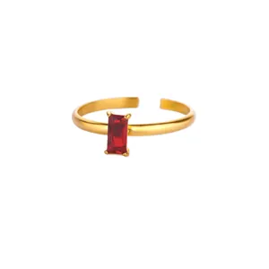 Close-up of golden adjustable ring with rectangle red zircon in four-prong setting